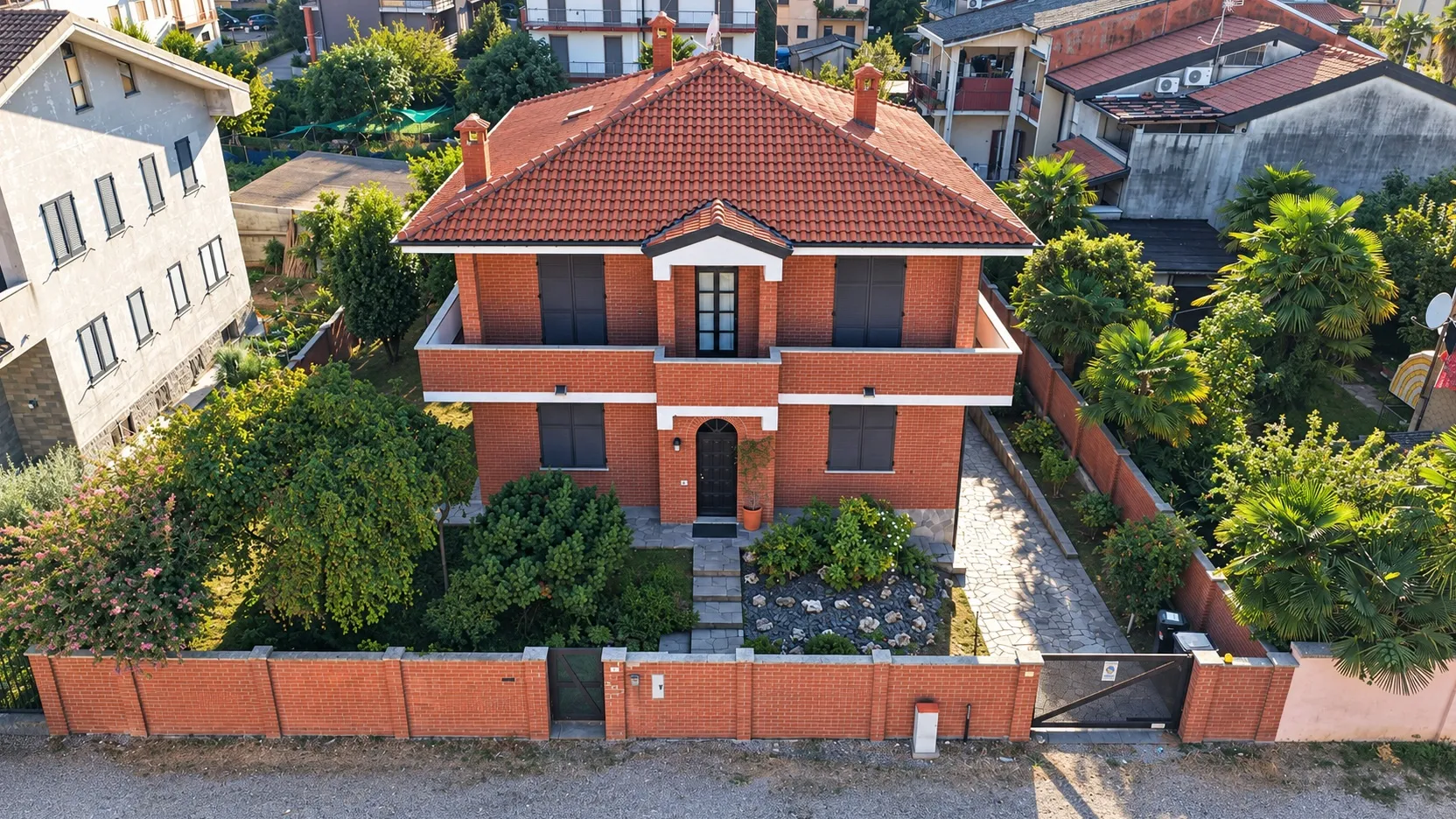 Veduta aerea dal drone: il tetto in coppi, il giardino e il vialetto, le case intorno
